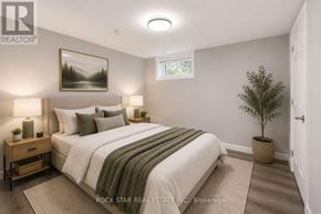 Brantford apartment for rent - A bedroom with a large bed and a potted plant.