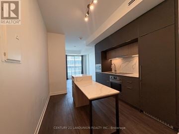 Toronto (Oakwood Village) condo for rent - A modern kitchen with dark wood floors and a marble countertop.