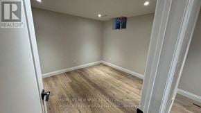 Pickering (West Shore) apartment for rent - A room with a wooden floor and a white door with a lock.