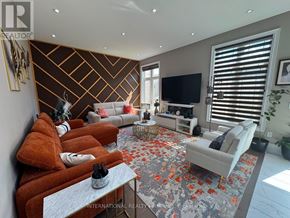 Caledon (Caledon East) apartment for rent - A living room with a grey rug and a brown sofa.