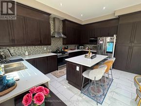 Caledon (Caledon East) apartment for rent - A kitchen with dark brown cabinets and a white island.