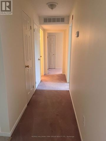 Barrie (Letitia Heights) condo for rent - A long hallway with white walls and a brown floor.