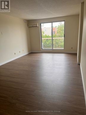 Barrie (Letitia Heights) condo for rent - A large empty room with a sliding glass door leading to a balcony.