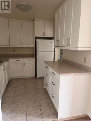 Barrie (Letitia Heights) condo for rent - A kitchen with white cabinets and a white refrigerator.