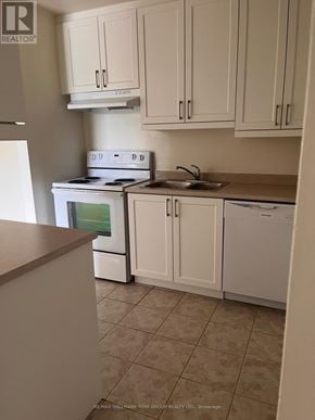 Barrie (Letitia Heights) condo for rent - A kitchen with white appliances and cabinets.