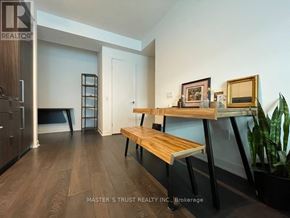 Toronto (Waterfront Communities) condo for rent - A room with a wooden bench and a picture frame on a table.