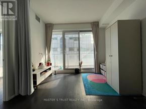 Toronto (Waterfront Communities) condo for rent - A room with a large window and a person standing by the window.
