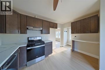 Sarnia apartment for rent - A kitchen with a stove top oven and a refrigerator.