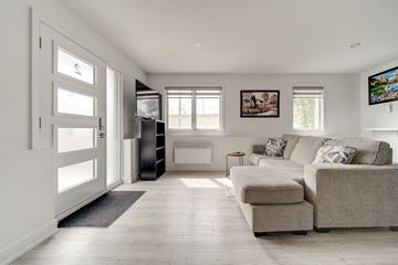 Gatineau (Hull) apartment for rent - A living room with a grey couch and a black cabinet.