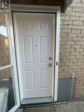 Mississauga (Hurontario) apartment for rent - A white door with a black handle is set in a brick wall.