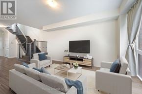 Thorold (Rolling Meadows) apartment for rent - A living room with a television, couches, and a staircase.