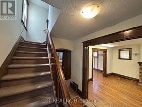 Ottawa apartment for rent - A staircase with a wooden banister and steps leading up to a doorway.