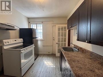 Ottawa apartment for rent - A kitchen with a white stove and black cabinets.