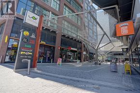 Toronto (Waterfront Communities) condo for rent - A street view of a shopping area with various store signs.