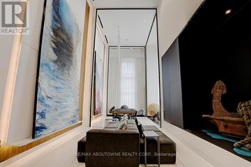 Toronto (Waterfront Communities) condo for rent - A modern living room with a large painting on the wall and a long table with chairs.