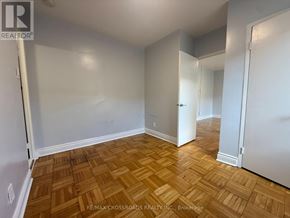 Toronto (Lawrence Park South) condo for rent - A room with wooden flooring and white walls.