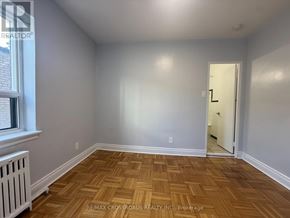 Toronto (Lawrence Park South) condo for rent - A room with wooden flooring and a door leading to another room.