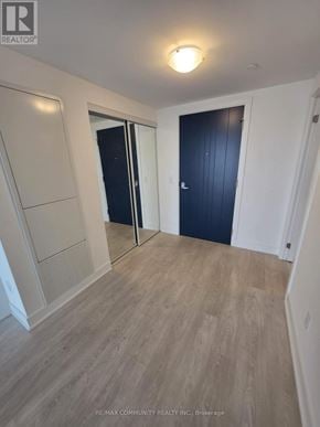 Oshawa (Windfields) condo for rent - A room with a wooden floor and a black door.