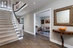 Oakville (Ga Glen Abbey) apartment for rent - A spacious hallway with a staircase, a mirror, and a wooden table.