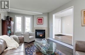 Oakville (Ga Glen Abbey) apartment for rent - A living room with a fireplace and a glass coffee table.