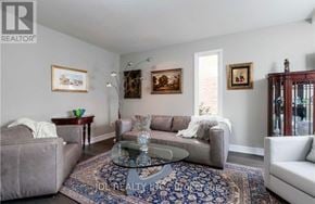 Oakville (Ga Glen Abbey) apartment for rent - A living room with a grey couch, a coffee table, and a rug.