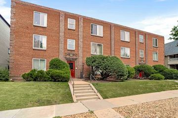 Denver apartment for rent - A red brick building with a red door and windows.