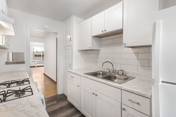 Denver apartment for rent - A kitchen with white cabinets and a marble countertop.