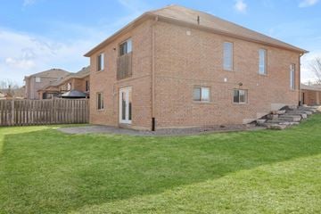 Barrie apartment for rent - A brick house with a green lawn in front.