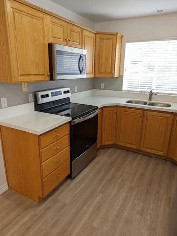 Orem apartment for rent - A kitchen with wooden cabinets and a black stove top oven.