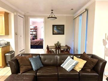 Provo apartment for rent - A living room with a brown leather couch and a painting on the wall.