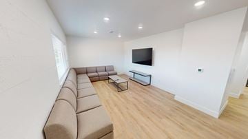 Provo apartment for rent - A living room with a long couch and a television on the wall.