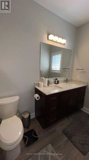 Whitby (Williamsburg) apartment for rent - A white toilet sits in a bathroom with a sink and mirror.
