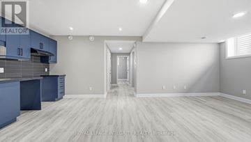 Russell apartment for rent - A spacious kitchen with blue cabinets and a white doorway leading to another room.