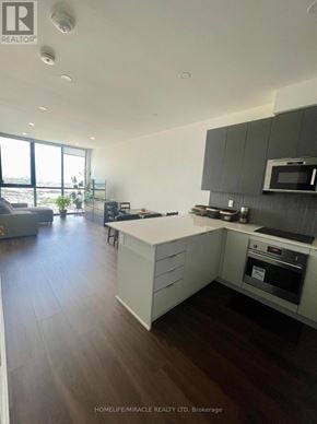Vaughan (Concord) condo for rent - A modern kitchen with dark wood floors and white cabinets.