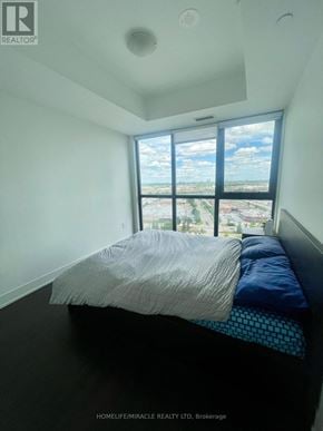 Vaughan (Concord) condo for rent - A bedroom with a large bed and a view of the city.