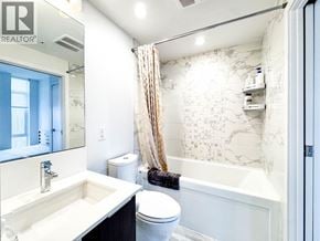 Vancouver apartment for rent - A bathroom with a marble wallpaper and a white toilet.