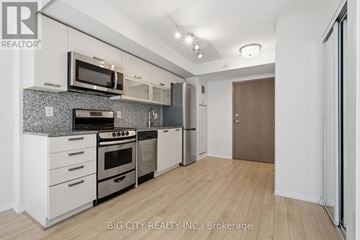 Toronto (Little Portugal) condo for rent - A modern kitchen with white cabinets and stainless steel appliances.