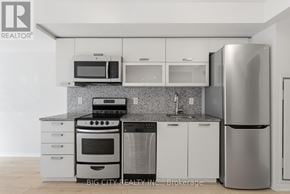 Toronto (Little Portugal) condo for rent - A modern kitchen with white cabinets and stainless steel appliances.
