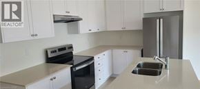 Mount Hope townhouse for rent - A kitchen with white cabinets and a stainless steel refrigerator.
