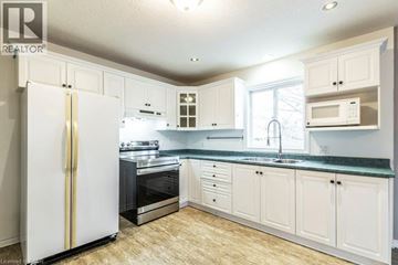 Kitchener apartment for rent - A kitchen with white cabinets and a white refrigerator.