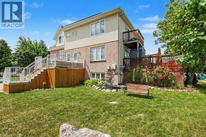 Kitchener apartment for rent - A house with a well-kept lawn and a bench in front.
