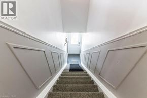 Kitchener apartment for rent - A staircase with a carpeted runner and white walls.