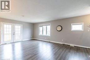 Kitchener apartment for rent - A large empty room with wooden floors and a clock on the wall.