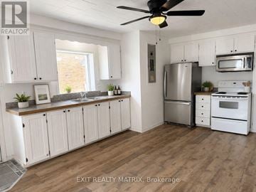 Casselman apartment for rent - A kitchen with white cabinets and a wood floor.