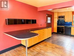 Ottawa apartment for rent - A kitchen with a red wall and wooden cabinets.