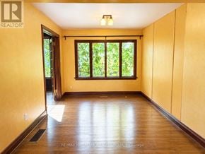 Ottawa apartment for rent - A room with wooden floors and a window with a view of trees.
