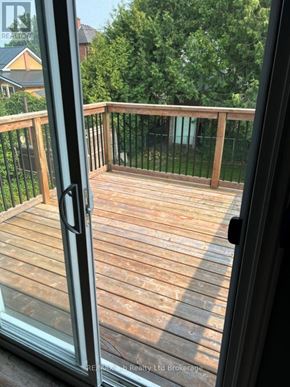 Woodstock (Woodstock - North) multi-family for rent - A glass door opens to a wooden deck with a black railing.