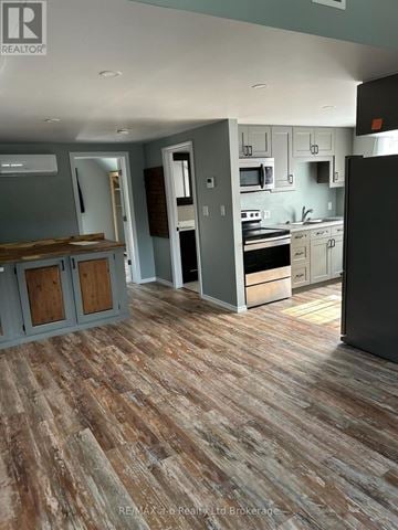 Woodstock (Woodstock - North) multi-family for rent - A kitchen with a wooden floor and a refrigerator.