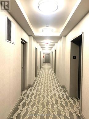 Toronto (Lansing-Westgate) condo for rent - A long hallway with a patterned floor and doors on both sides.