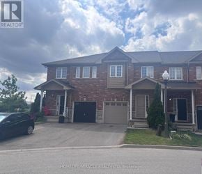 Hamilton (Lakeshore) townhouse for rent - A house with a black car parked in front.